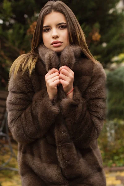 Pretty teen girl is wearing fur coat — Stock Photo, Image