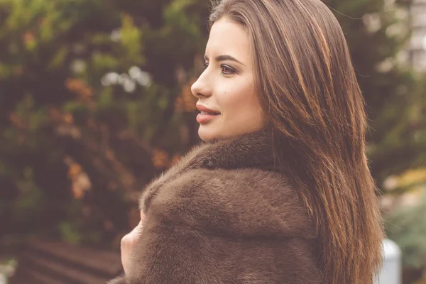 Pretty teen girl is wearing fur coat — Stock Photo, Image