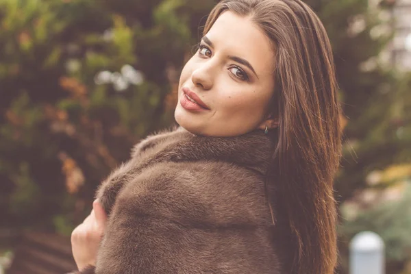 Pretty teen girl is wearing fur coat — Stock Photo, Image