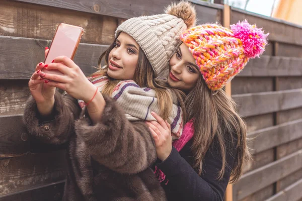 Две симпатичные девушки делают селфи со смартфоном — стоковое фото
