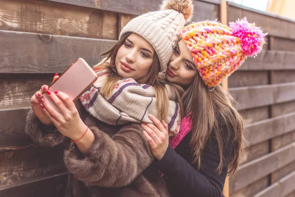 Duas garotas bonitas estão tirando selfie com smartphone — Fotografia de Stock