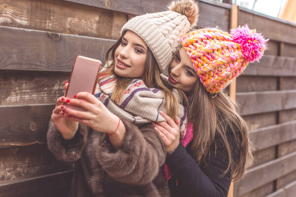 Two pretty girl are taking selfie with smartphone
