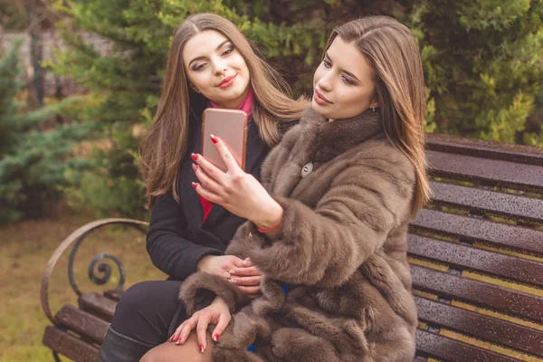 Dos chicas se están tomando selfie con smartphone —  Fotos de Stock