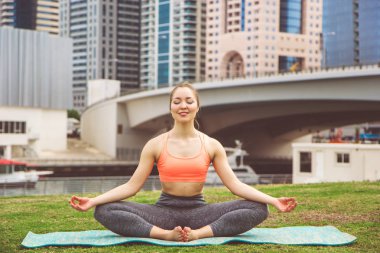 Genç kız Dubai şehirde Yoga meditasyon yapıyor