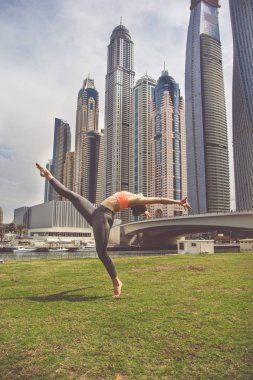 Genç kız gökdelenler karşı germe yapıyor