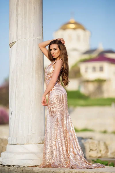 Vrouw draagt luxe jurk in de buurt van antieke kolom — Stockfoto