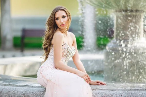Kvinnan bär lyx klänning nära fountain — Stockfoto