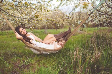 Mutlu kız annesi ile açık havada hamakta dinleniyor