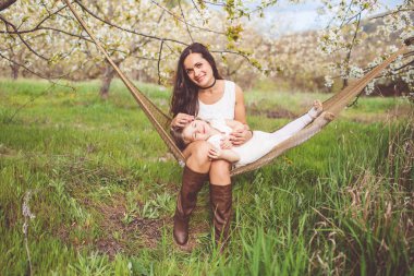 Mutlu anne ve kızı hamakta açık havada dinlenme