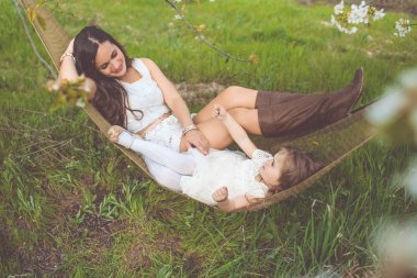 Mutlu anne ve kızı hamakta açık havada dinlenme