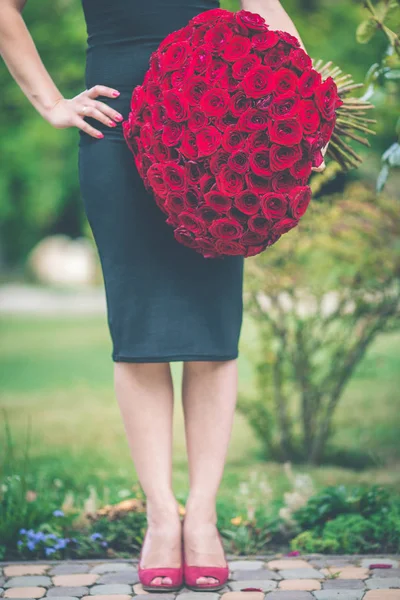 우아한 아름 다운 여자는 블랙 패션을 입고 드레스 101 빨간 장미의 큰 꽃다발을 들고 있다 — 스톡 사진