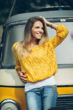 Mutlu gülümseyen kız eski retro otobüs, sonbahar konsepti yakınındaki sarı kazak giyiyor