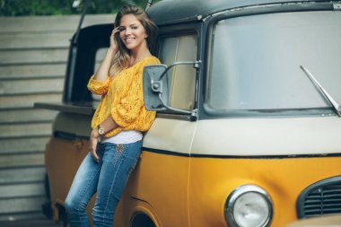 Mutlu gülümseyen kız eski retro otobüs, sonbahar konsepti yakınındaki sarı kazak giyiyor