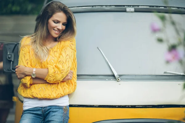 Щаслива усміхнена дівчина носить жовтий светр біля старого ретро-автобуса, осіння концепція — стокове фото