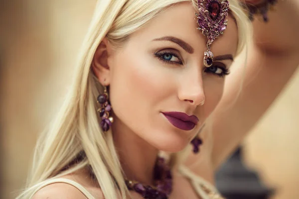 Beautiful portrait of woman with a lilac make-up and manicure on nails is wearing jewelry with purple stones — Stock Photo, Image