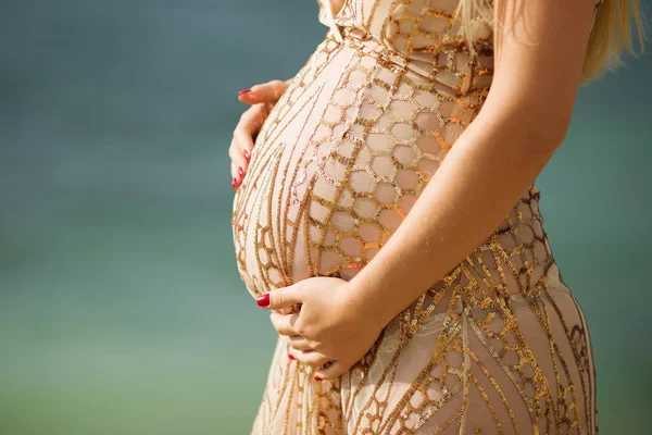 Mulher grávida bonita sobre fundo do mar está vestindo vestido de luxo — Fotografia de Stock