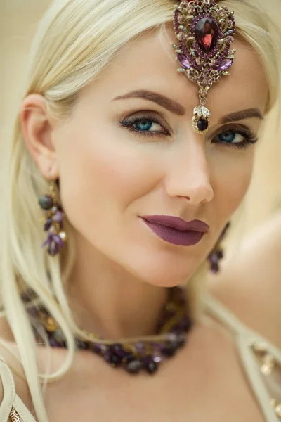 Vackra närbild porträtt av kvinna med en lila makeup och manikyr på naglarna bär smycken med lila stenar — Stockfoto