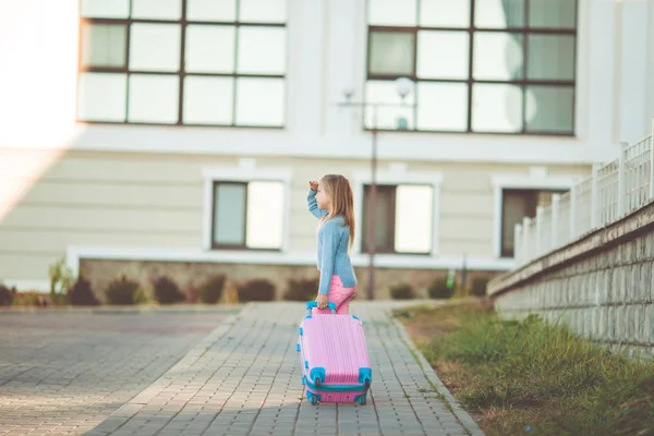 Szczęśliwa dziewczynka z różowy walizka jest gotowy do podróży na wakacje — Zdjęcie stockowe