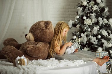 Mutlu Noeller ve mutlu tatil. Uzun saçlı güzel sarışın kız büyük oyuncak ayı tutuyor