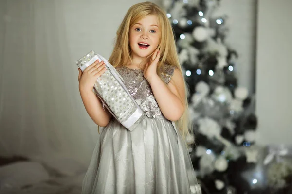 Feliz Natal e Feliz Natal. Menina loira bonita com cabelos longos está segurando presente xmas — Fotografia de Stock