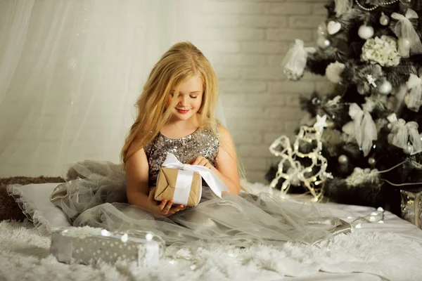 Joyeux Noël et Joyeuses Fêtes. Jolie fille blonde tient cadeau de Noël — Photo