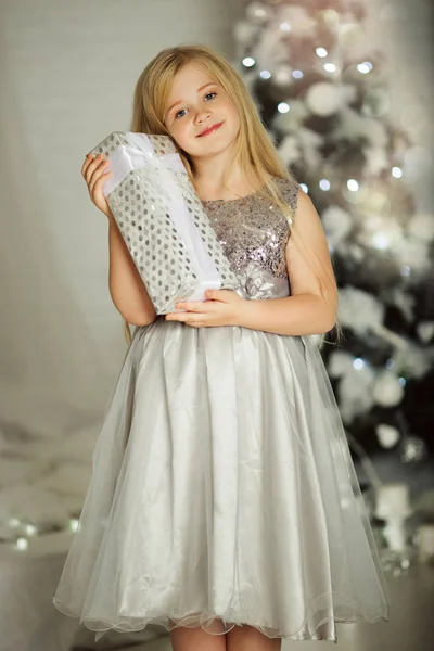 Merry Christmas and Happy Holiday. Pretty blonde girl is holding xmas gift — Stock Photo, Image