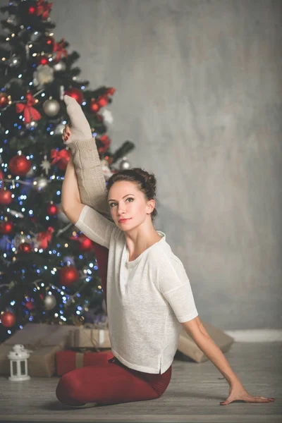 Schöne flexible junge Frau treibt Sport in der Nähe von Weihnachtsbaum, Sport und Urlaubskonzept — Stockfoto