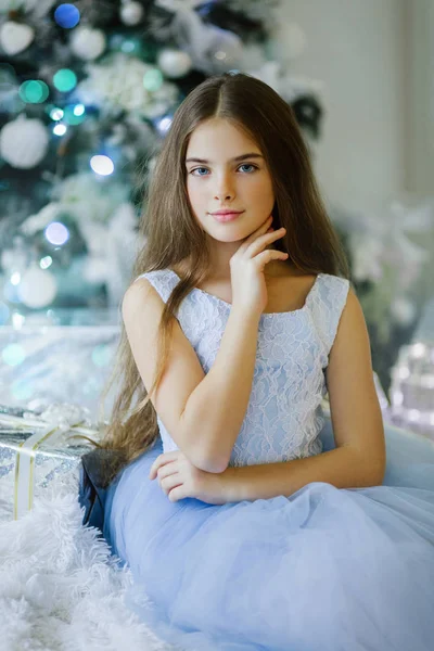 Jolie fille est assise près de l'arbre de Noël — Photo