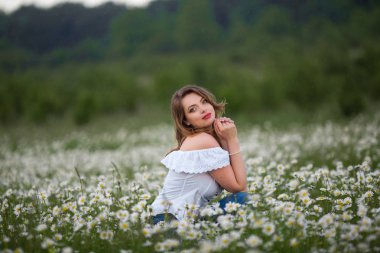 Güzel mutlu kadın papatya alan üzerinde beyaz giyen, elbise bahar kez