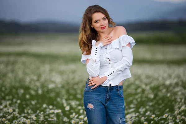 Красива дівчина на ромашковому полі, весняний час — стокове фото