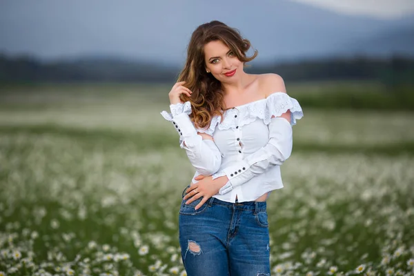 Mooi meisje op het veld van kamille is het dragen van casual kleding, lente — Stockfoto