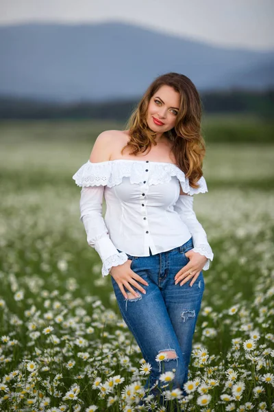 Vacker flicka på fältet camomile bär casual kläder, våren — Stockfoto