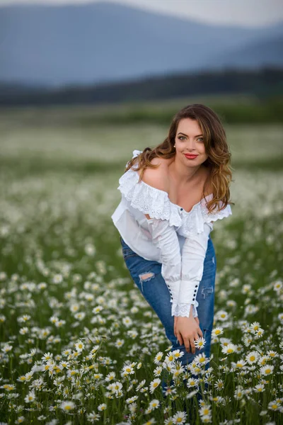 Schöne glücklich lächelnde Frau auf dem Kamillenfeld trägt weißes Kleid, Frühlingszeit — Stockfoto