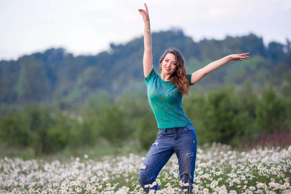 Hermosa mujer feliz sonriente en el campo de manzanilla está caminando bajo la lluvia, la primavera —  Fotos de Stock