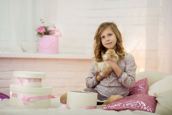 Pretty little girl at home is playing with rabbit — Stock Photo, Image