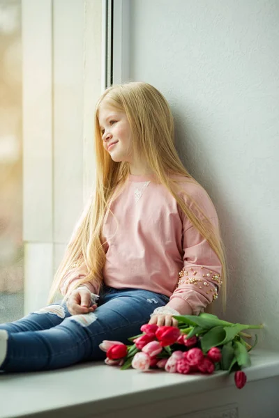Ładny blond dziewczyna z bukietem kwiatów tulipan różowy. Koncepcja Wielkanoc — Zdjęcie stockowe