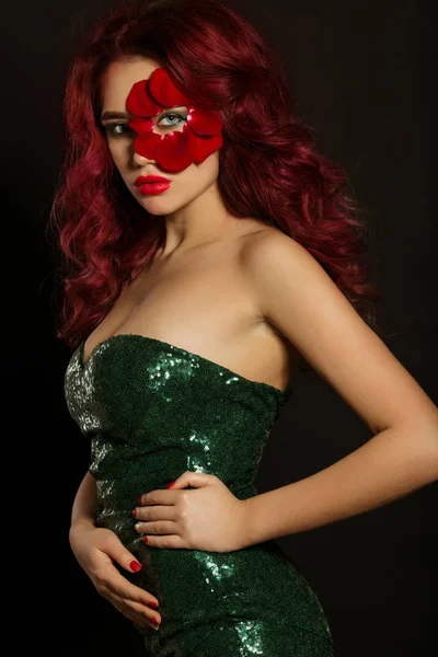 Ritratto di bella donna sexy di lusso con trucco creativo e petali di rosa rossa del suo viso indossa un vestito verde lucido — Foto Stock