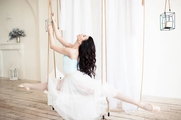 Junge schöne Ballerina sitzt auf Bindfäden im Studio — Stockfoto