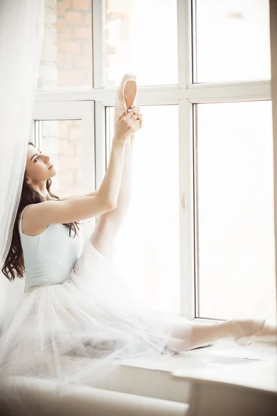 Красива дівчина балерини сидить на підвіконні в студії — стокове фото
