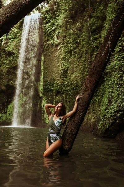 Hermosa chica sexy bajo una cascada en Indonesia . — Foto de Stock