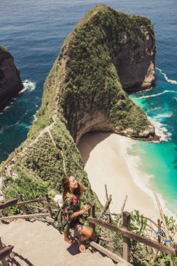 Güzel kız Kelingking Körfezi 'nde seyahat ediyor. Nusa Penida adası, Endonezya.