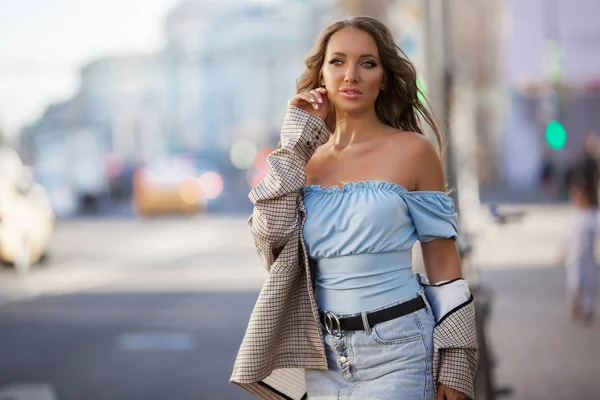 Mooie jonge vrouw draagt stijlvolle kleren lopen op straat — Stockfoto