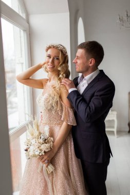 Lovely couple groom and bride in studio with light white interior. Wedding concept.