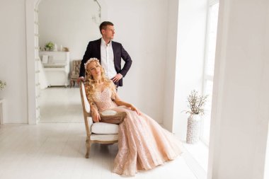 Lovely couple groom and bride in studio with light white interior. Wedding concept.