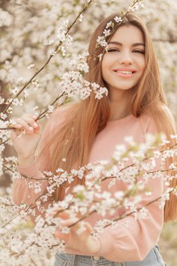 Bahar çiçekleri arasında güzel doğal bir kadın.