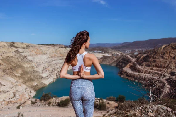 若いですスリム女性あります練習ヨガで山の湖 — ストック写真