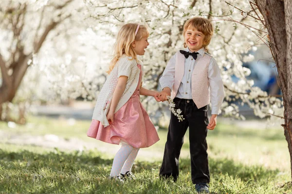 快乐的妹妹和弟弟正在户外樱花花园里玩耍 春天的时间 — 图库照片