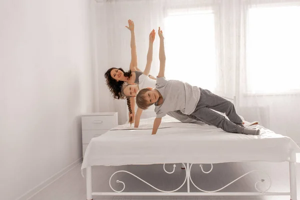 快乐的家庭母亲 女儿和儿子在家里的白色卧室里玩得很开心 待在家里 守规矩 — 图库照片