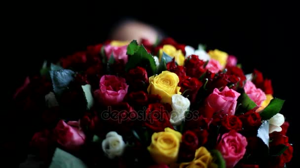 Gyönyörű romantikus nő, egy nagy csokor virágnak a karjában szag egy illatos, színes rózsák fekete háttér. 1920 x 1080
