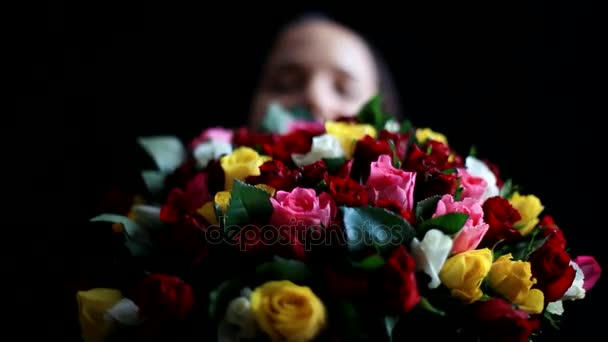Gyönyörű romantikus nő, egy nagy csokor virágnak a karjában szag egy illatos, színes rózsák fekete háttér. 1920 x 1080